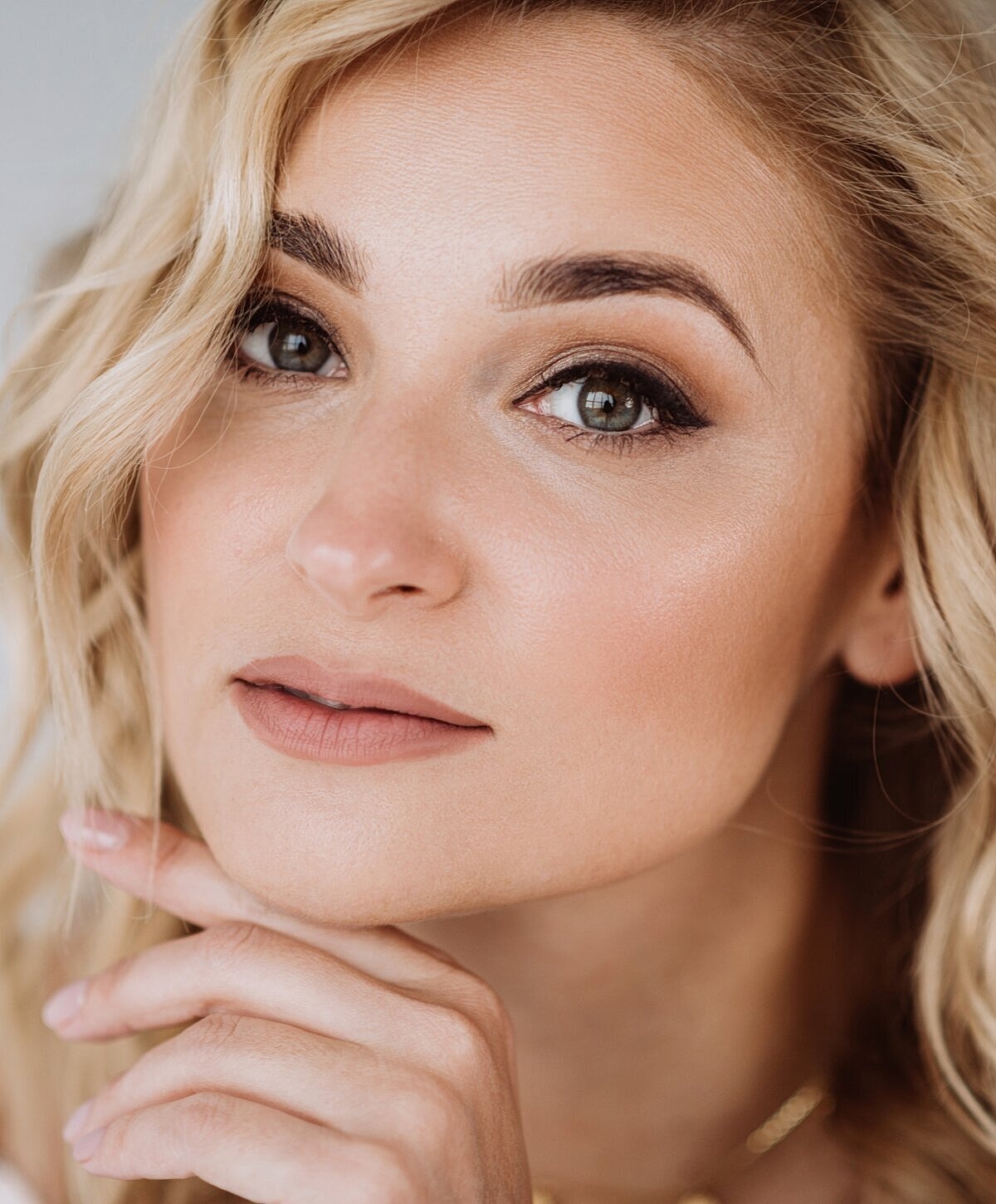 Close-up of a woman with blonde wavy hair.