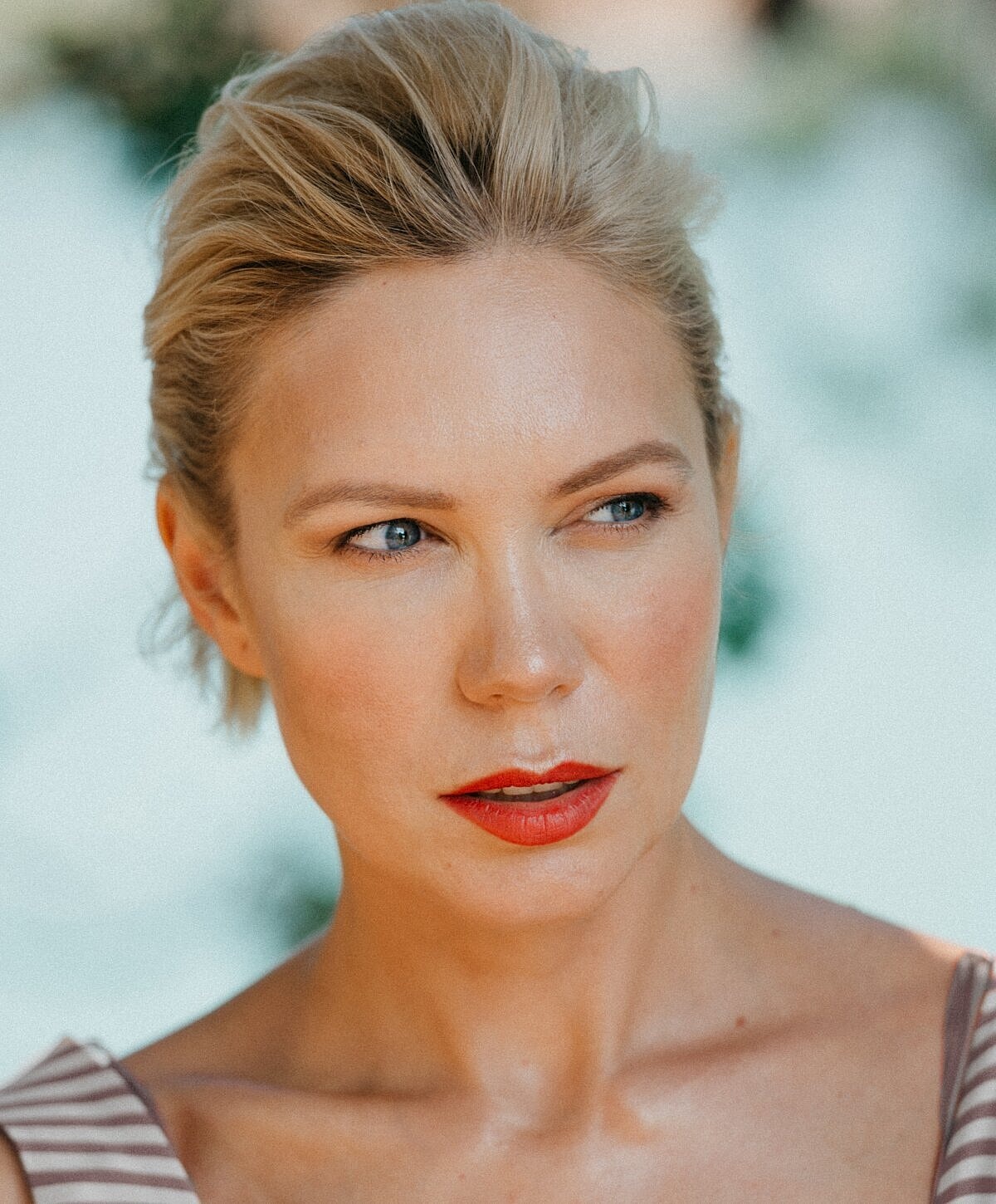 Woman with blonde hair and red lipstick.