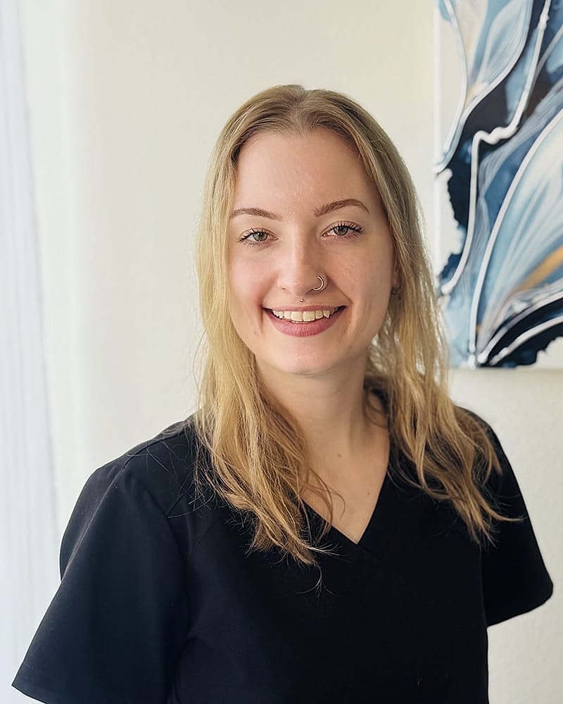 Smiling person in black shirt, modern background.