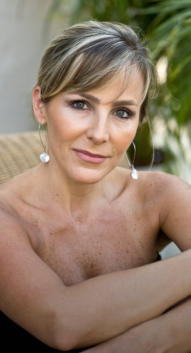 Woman with elegant hairstyle and earrings, outdoors.