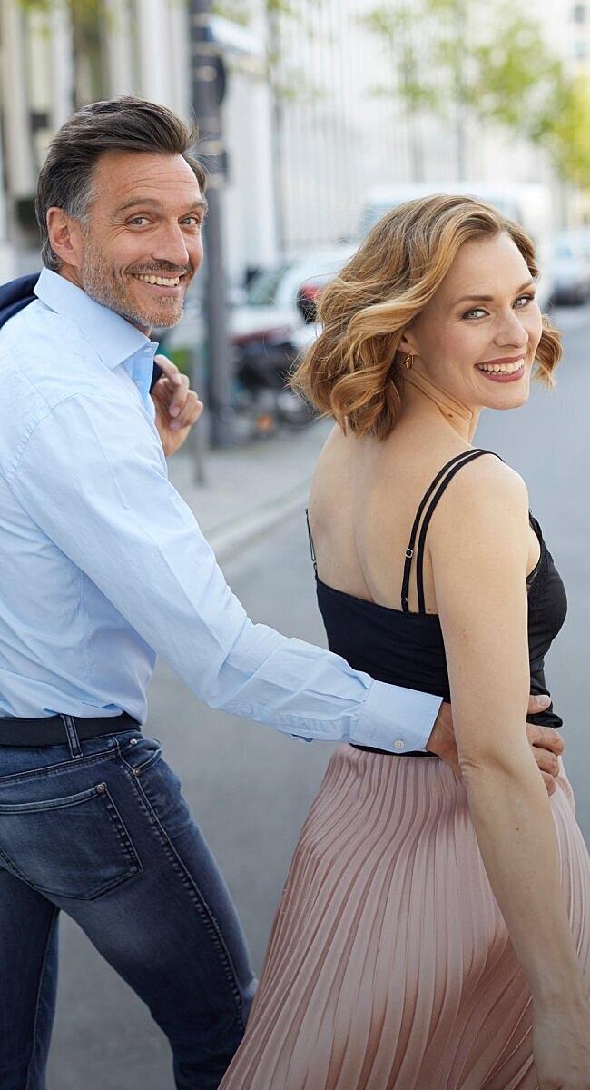 Romantic couple enjoying a playful moment outdoors.