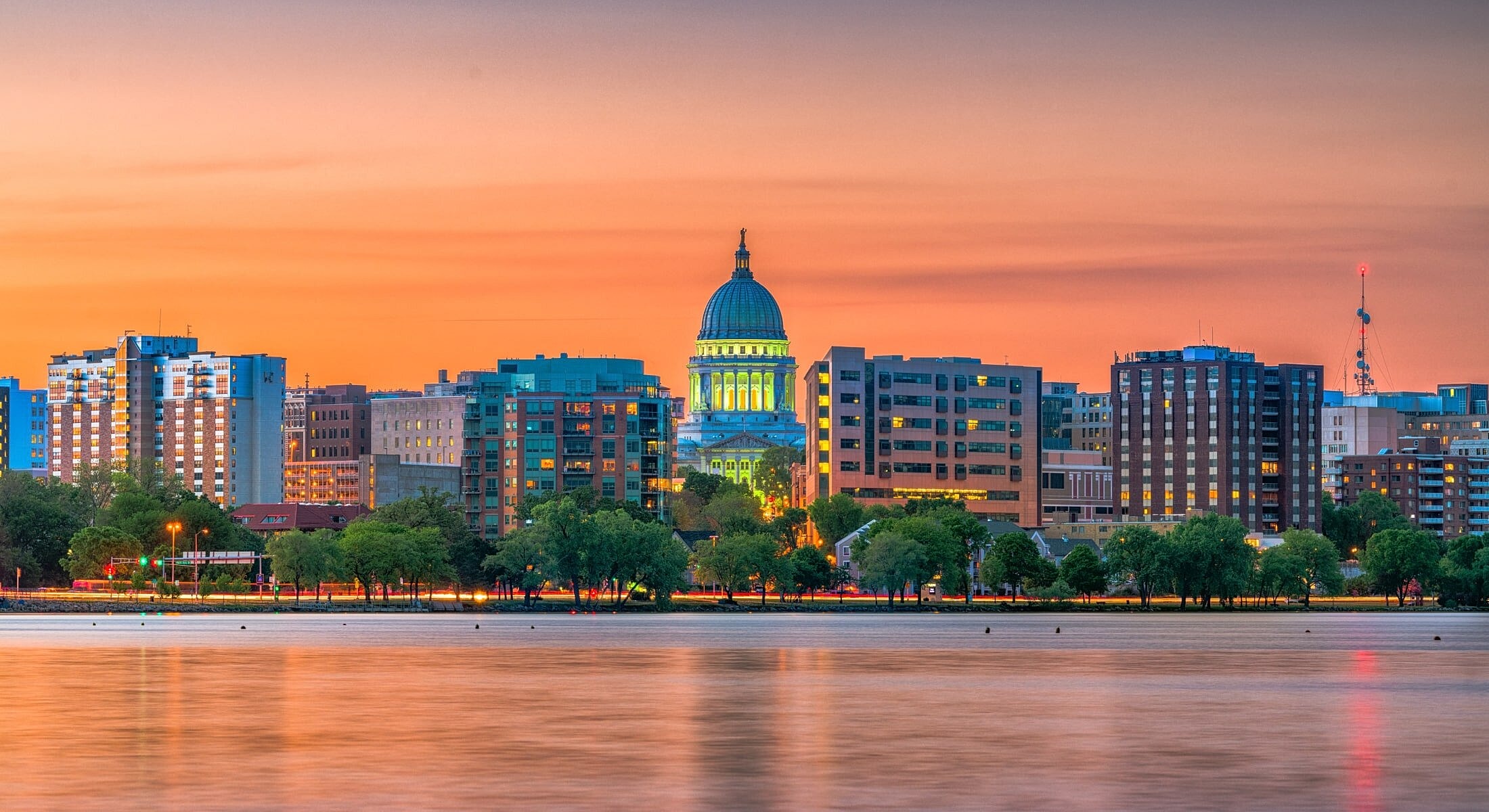 Sunset over city skyline with dome building.